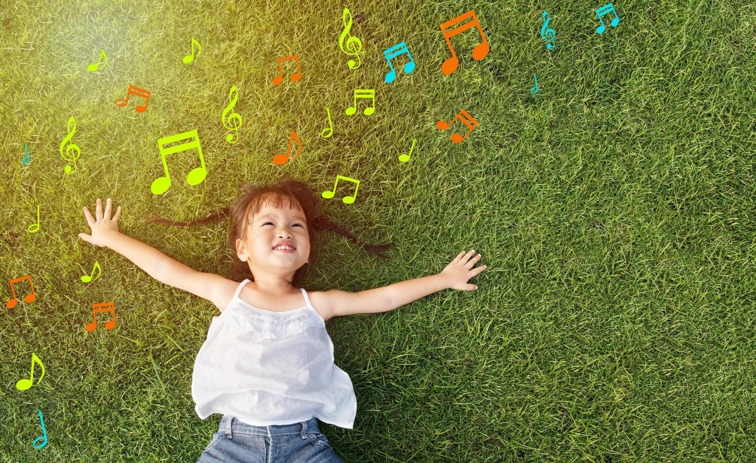 Asian little girl smile and lay on grass with music note background