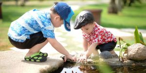 To barn leker ved en vannpytt