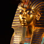 En skinnende kopi av Tutankhamons berømte gullmaske, dekorert med blå striper og fine mønstre slik faraoen i Egypt brukte for over 3000 år siden.