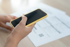 Vider en som hollder en mobil i hånden og scanner en qr kode på et papir