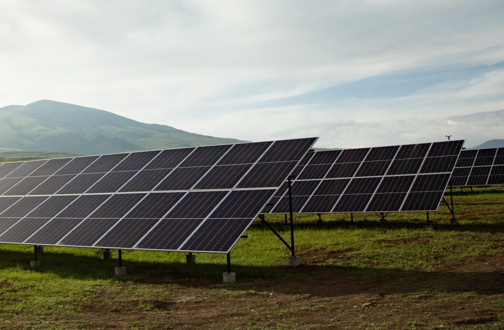 Bilde av solcellepanel som står på skrå på et gress.