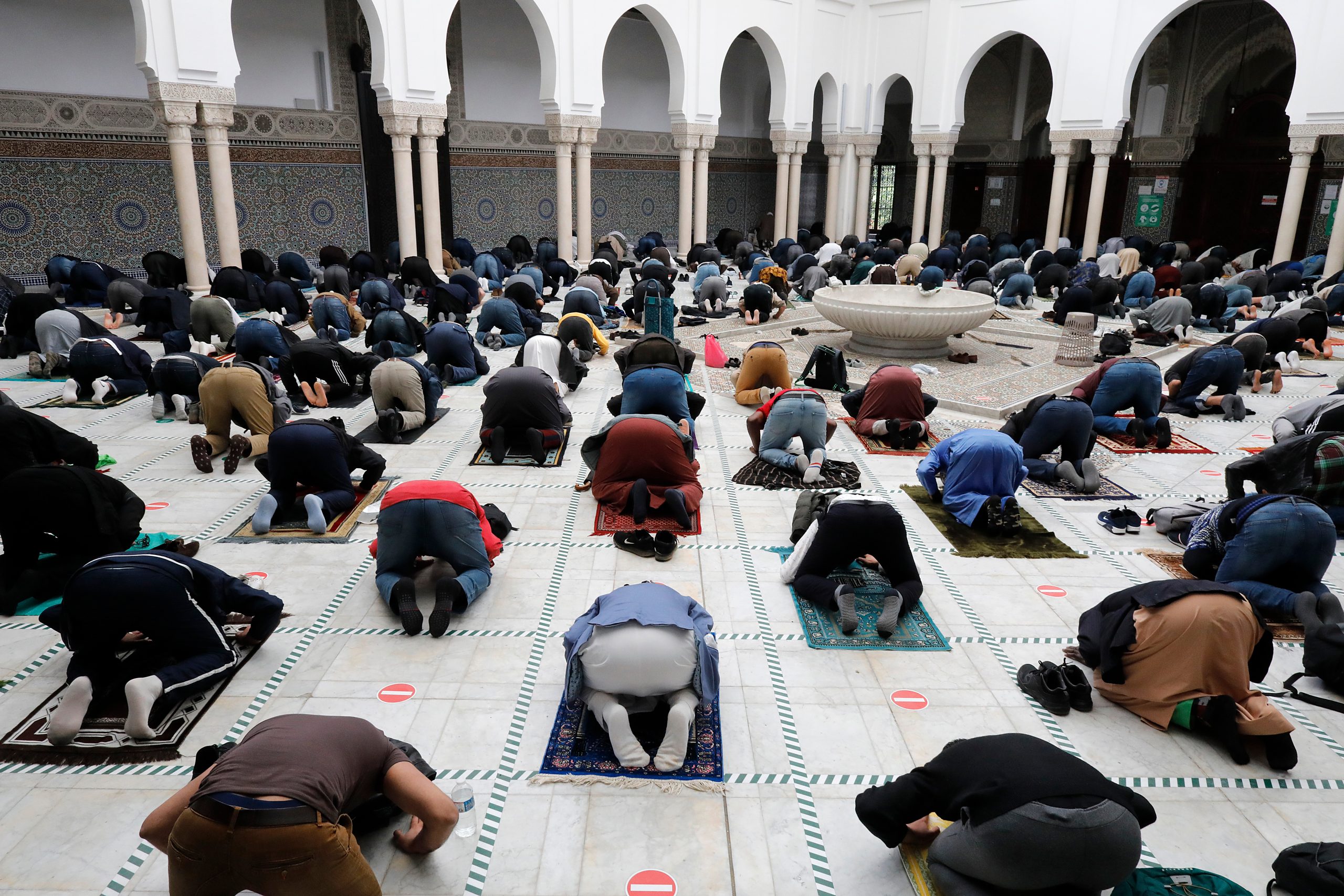 Bilde av personer som bøyer seg i bønn i en moske.