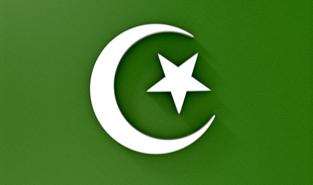 A metal islamic crescent moon and star on a green textured background