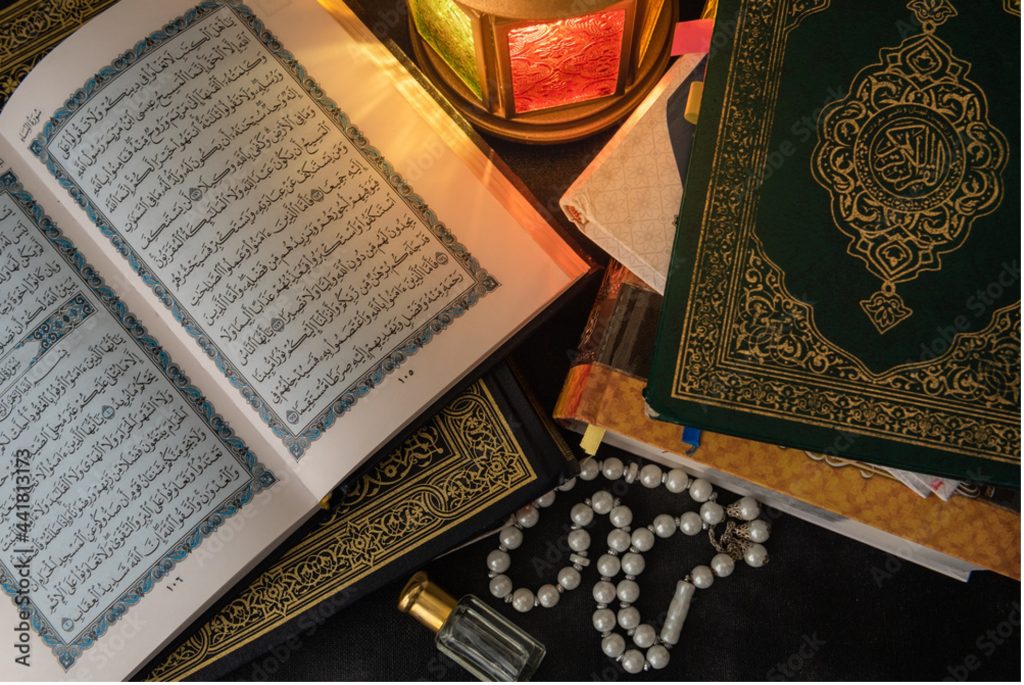 Bilde av koranen og andre bøker som er oppslått på et bord. 