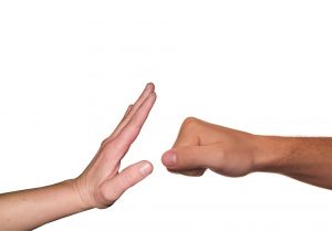 Bilde som viser to hender, en som illustrerer stopp, og en annen hånd med knyttneve som slår