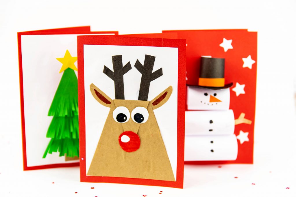 bilde av tre hjemmelagde julekort, ett med en snømann, ett med reinsdyr og ett med et juletre