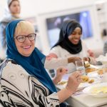 Tre damer som spiser mat på Id- festen