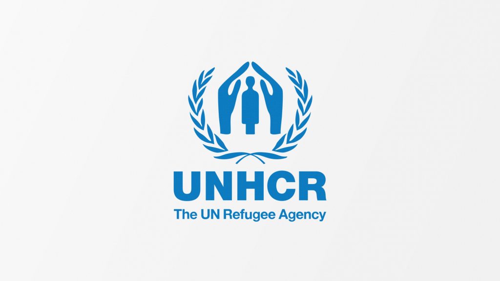 hvit bakgrunn, tekst og tegning iblått. Teksten E UNHCR tegningen er to olivengrener og to hender som holders over et menneske