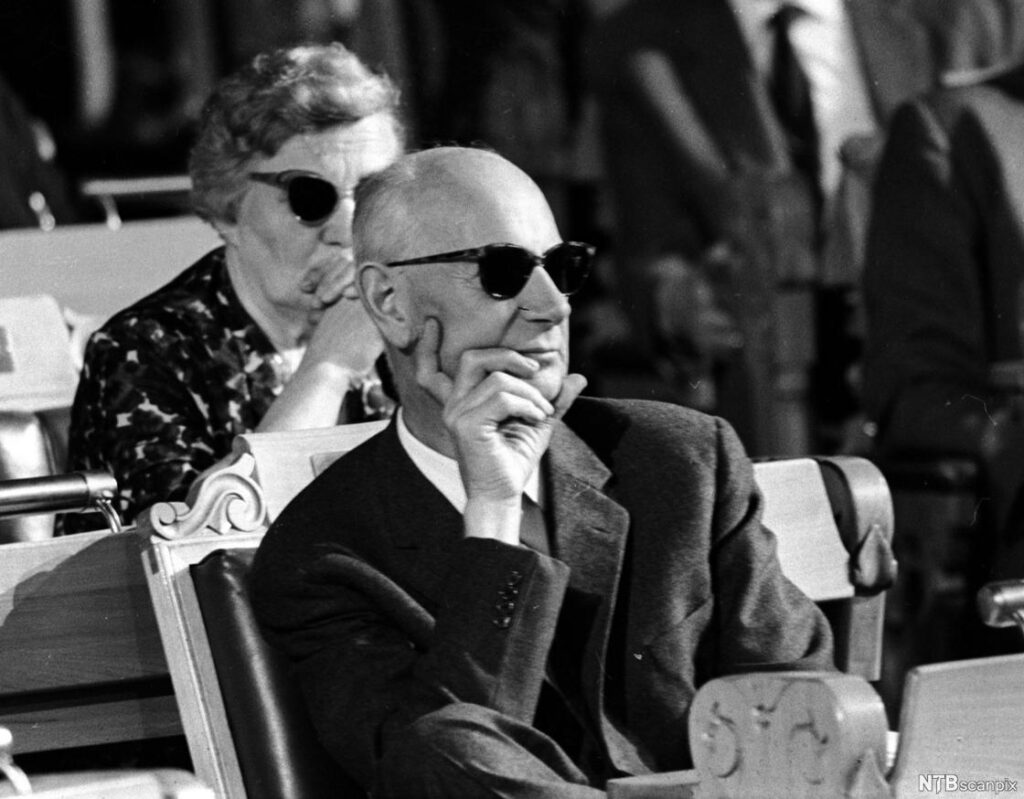 svart- hvitt foto av en mann som sitter og ser på noe