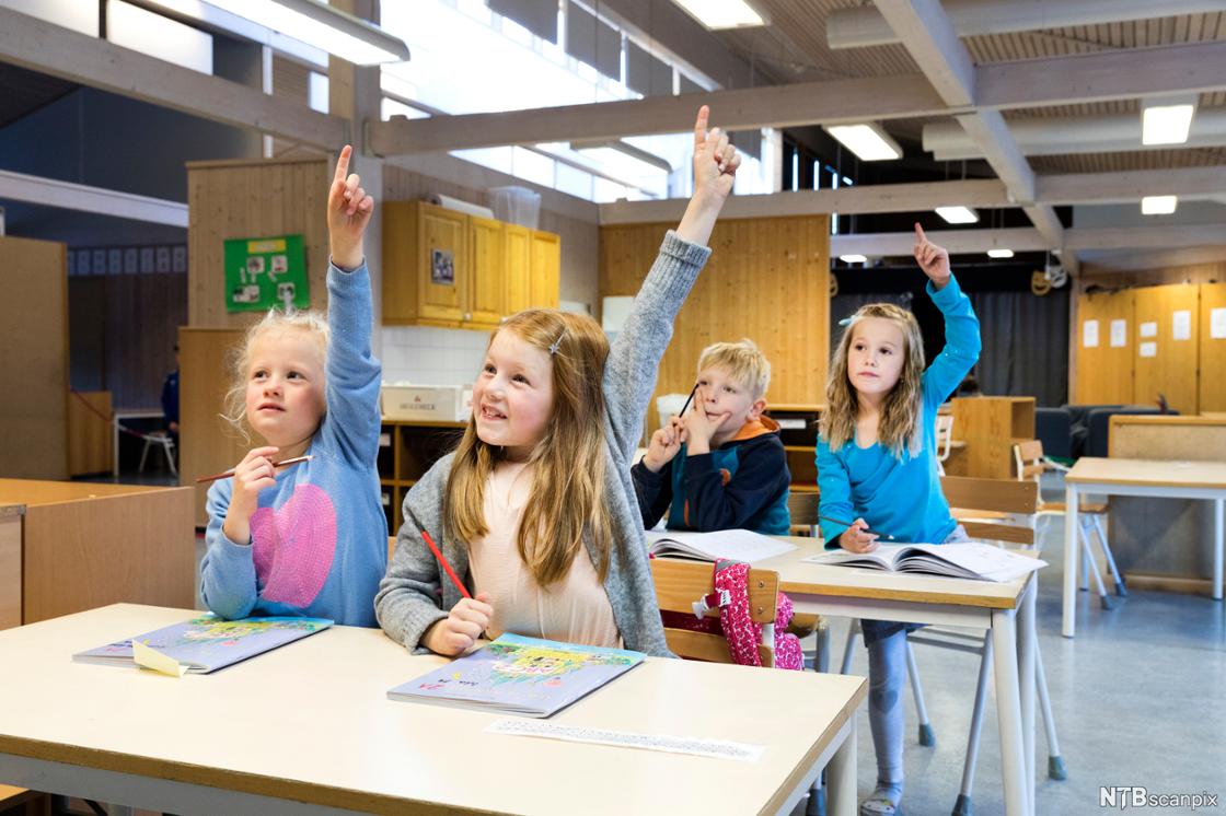 Bilde av elever som slitter i klassen. Noen av dem rekker opp hånda.
