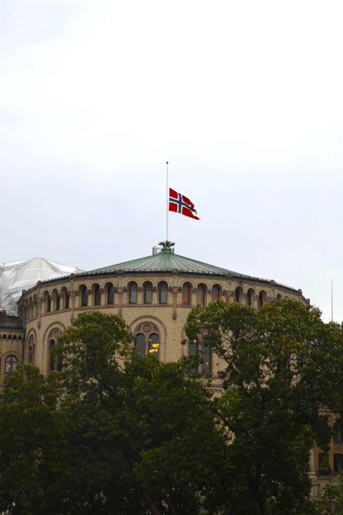 Bilde av taket på Stortinget i Oslo som flagger på halv stang