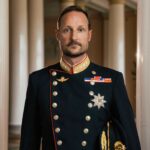 Fotografi av en mann med uniform. Noen medaljer er festet til uniformen som har sølvknapper og gullfarget krage.